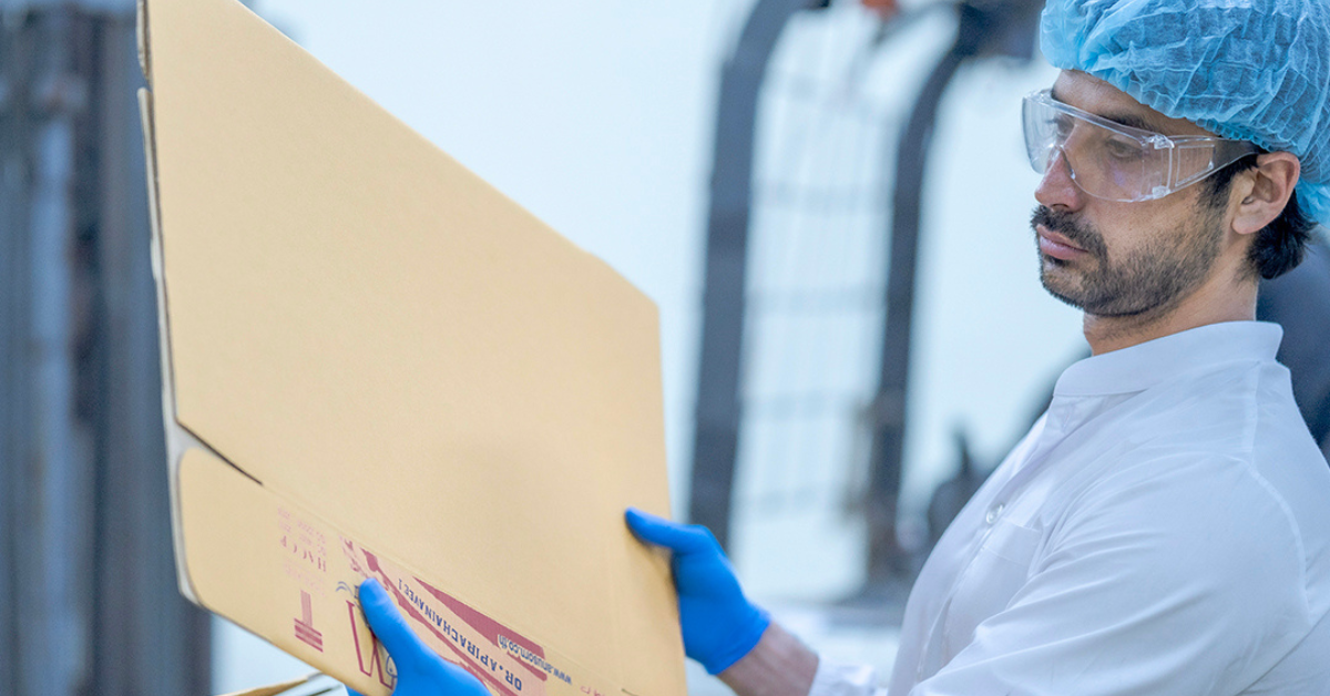 Worker inspecting a large cardboard for making private label product.